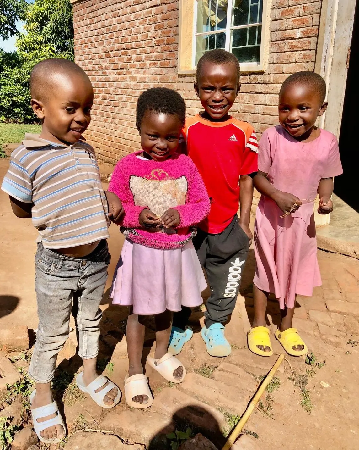 Four children standing together outside the feeding hall in Mtonda Village