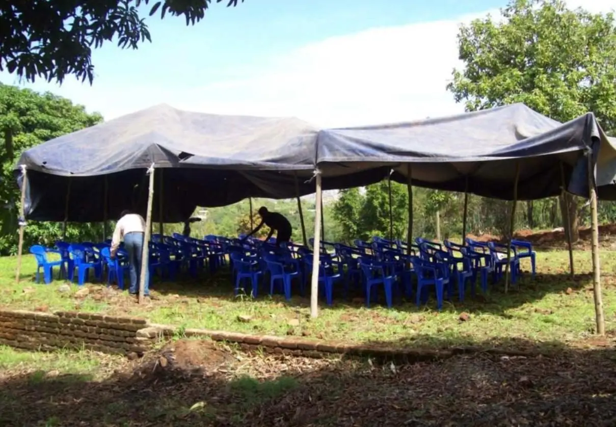 A large rented tent with rows of blue chairs set out for the children